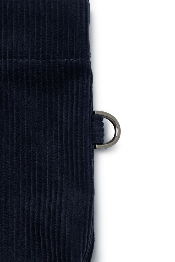 **코듀로이 에코 백 - 네이비 (P255ATO413)**

부드러운 코듀로이 소재와 면, 폴리에스테르 혼방으로 제작된 네이비 컬러의 미디엄 사이즈 에코 백입니다. 심플하고 베이직한 디자인으로 일상, 여행 등 다양한 TPO에 활용하기 좋습니다. 가방 내부에는 텀블러 포켓과 내부 포켓이 있어 실용성을 높였으며, D링을 활용하여 측면 장식을 부착할 수 있습니다. 가볍고 부드러운 촉감으로 편안하게 사용 가능하며, 자수 로고가 디자인 포인트입니다. 스타일은 캐주얼, 미니멀, 클래식 무드를 연출합니다.
