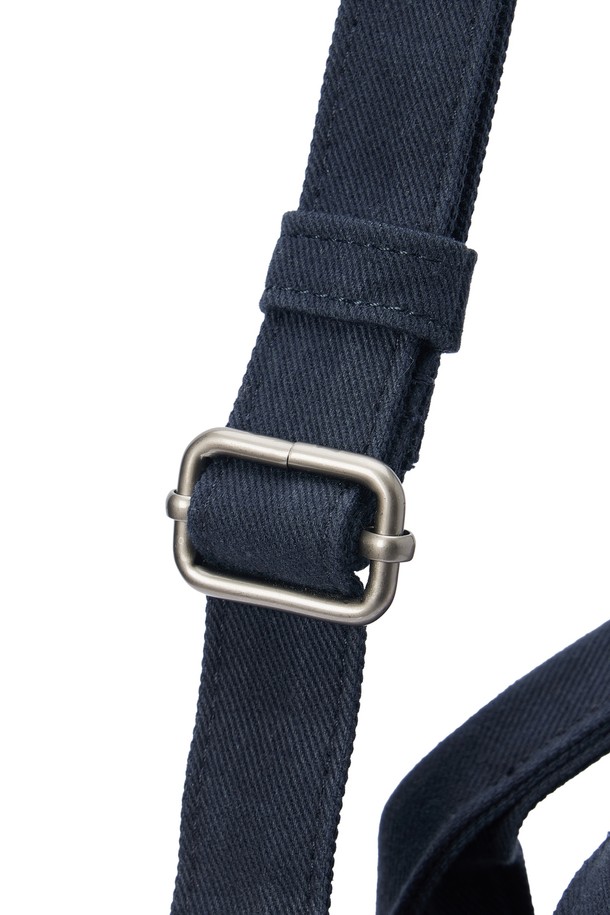 SMALL TOTE BAG (스몰 토트백) - 네이비 컬러의 남성용 토트백입니다. 면 소재로 제작되었으며, 스몰 사이즈의 사각 쉐입에 로고 패턴과 스터드/찡 및 자수 디자인 장식이 돋보입니다. 2WAY 기능과 손잡이로 다양한 연출이 가능하며, 넓은 개구부와 자연스러운 워싱 텍스처가 특징입니다. 오픈형 잠금 방식으로 편리하며, 크로스백으로도 활용 가능하여 동네 마실룩, 쇼핑룩 등 캐주얼, 미니멀, 시티보이 스타일을 연출하기 좋습니다.
