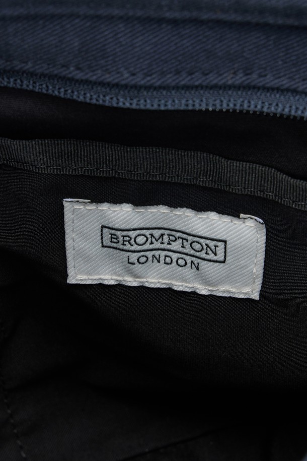 SMALL TOTE BAG (스몰 토트백) - 네이비 컬러의 남성용 토트백입니다. 면 소재로 제작되었으며, 스몰 사이즈의 사각 쉐입에 로고 패턴과 스터드/찡 및 자수 디자인 장식이 돋보입니다. 2WAY 기능과 손잡이로 다양한 연출이 가능하며, 넓은 개구부와 자연스러운 워싱 텍스처가 특징입니다. 오픈형 잠금 방식으로 편리하며, 크로스백으로도 활용 가능하여 동네 마실룩, 쇼핑룩 등 캐주얼, 미니멀, 시티보이 스타일을 연출하기 좋습니다.
