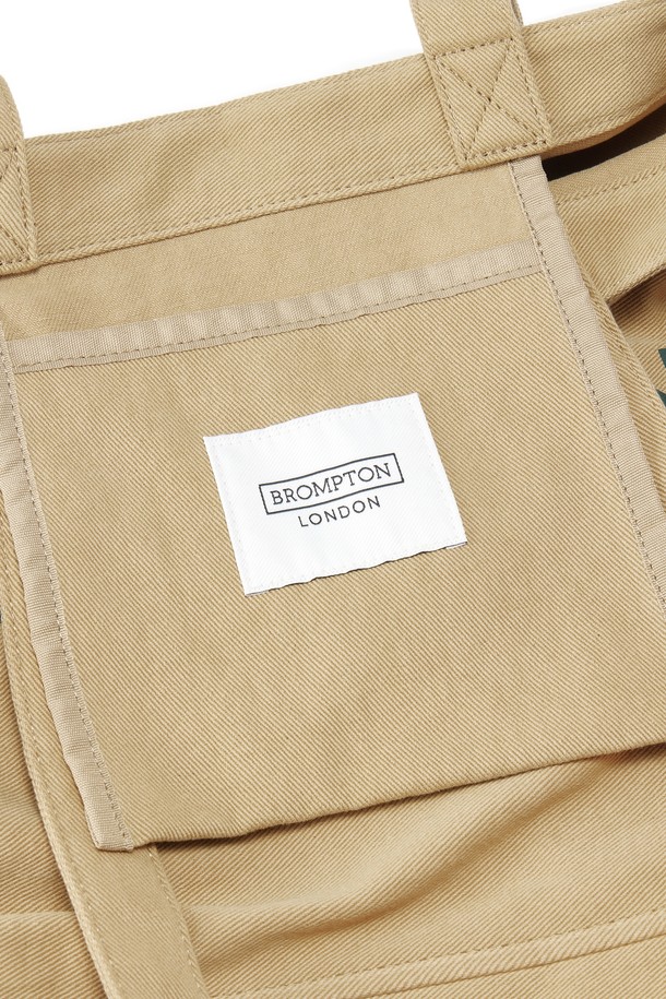 1975 로고 에코백 - BEIGE (P255ATO410)은 면과 폴리에스테르 혼방 소재로 제작되어 부드러운 촉감이 돋보이는 미디엄 사이즈의 사각 에코백입니다. 베이지와 오렌지 컬러의 로고 패턴이 특징이며, 텀블러 전용 포켓과 D링 디자인으로 실용성을 더했습니다. 바이오워싱 처리로 내구성이 뛰어나 데일리 백으로 활용하기 좋습니다.
