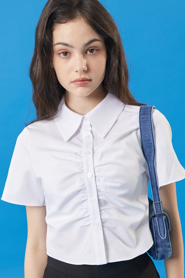 여성용 화이트 색상의 셔링 크롭 반팔 셔츠입니다. 얇은 두께감으로 여름에 착용하기 좋으며, 셔츠 칼라와 버튼 여밈 디테일이 특징입니다. 슬림핏 디자인으로 글래머러스한 실루엣을 연출하며, 페미닌하고 캐주얼한 무드를 동시에 느낄 수 있습니다.
