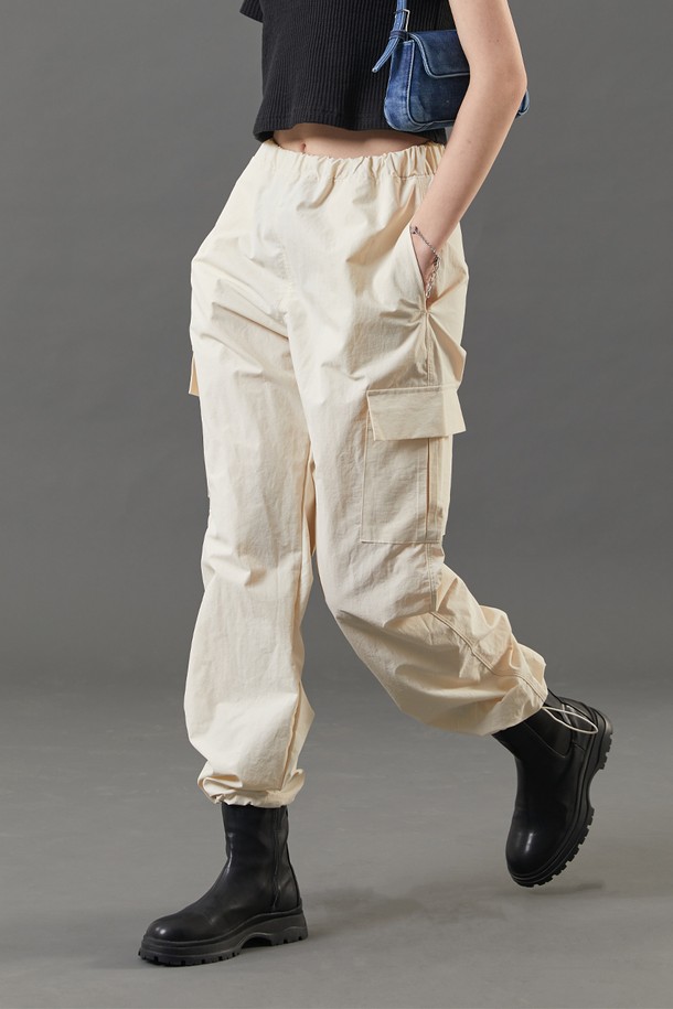 여성용 아이보리 색상의 여름 쿨링 카고 팬츠입니다. 얇고 부드러운 나일론 소재로 제작되었으며, 쿨링, 속건, 통기 기능과 바스락 소재, 투웨이 에어 서큘레이션, 365 FAST DRY 기능이 특징입니다. 와이드 핏에 밴딩 허리로 편안한 루즈핏 긴바지입니다.
