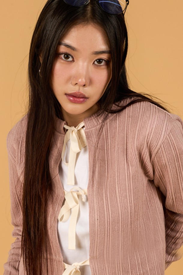 페미닌하고 캐주얼한 무드를 연출하는 미디 기장의 크롭 니트 가디건입니다. 얇은 두께감과 부드러운 촉감의 니트 소재로 제작되었으며, 라운드 넥과 긴 소매, 리본 스트랩 디자인이 특징입니다. 핑크, 그레이, 블랙 세 가지 색상으로 제공되며, 봄, 가을 시즌에 활용하기 좋은 FREE 사이즈 제품입니다.
