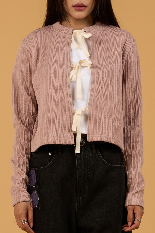 페미닌하고 캐주얼한 무드를 연출하는 미디 기장의 크롭 니트 가디건입니다. 얇은 두께감과 부드러운 촉감의 니트 소재로 제작되었으며, 라운드 넥과 긴 소매, 리본 스트랩 디자인이 특징입니다. 핑크, 그레이, 블랙 세 가지 색상으로 제공되며, 봄, 가을 시즌에 활용하기 좋은 FREE 사이즈 제품입니다.
