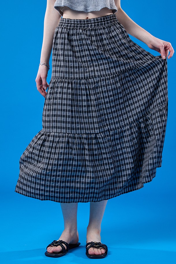 릴리 에어리 쿨링 마몽 체크 롱스커트는 여름철 일상에서 쾌적하게 착용 가능한 블랙 색상의 여성용 스커트입니다. 부드러운 폴리에스테르 소재의 A라인 티어드 디자인으로, 얇은 두께와 통기성, 냉감 및 속건 기능까지 갖춰 시원하게 입을 수 있으며, 밴딩과 안감 처리로 편안함과 비침 방지 기능까지 더했습니다. 루즈핏으로 주름 디자인이 돋보이는 체크 패턴 롱스커트입니다.
