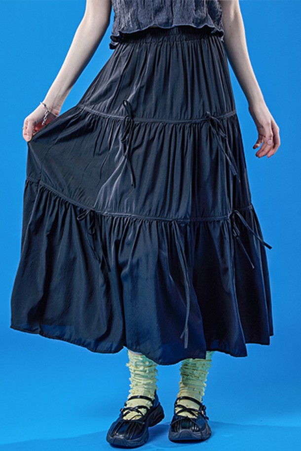 쿨링 기능성 원단으로 제작된 블랙 색상의 롱스커트입니다. 밴딩, 리본, 주름 디테일이 특징이며, 플레어 및 티어드 치마핏으로 페스티벌이나 프레피 스타일을 연출하기에 좋습니다. 여름철 일상에서 시원하고 쾌적하게 착용 가능한 얇은 두께의 롱 플레어스커트입니다.
