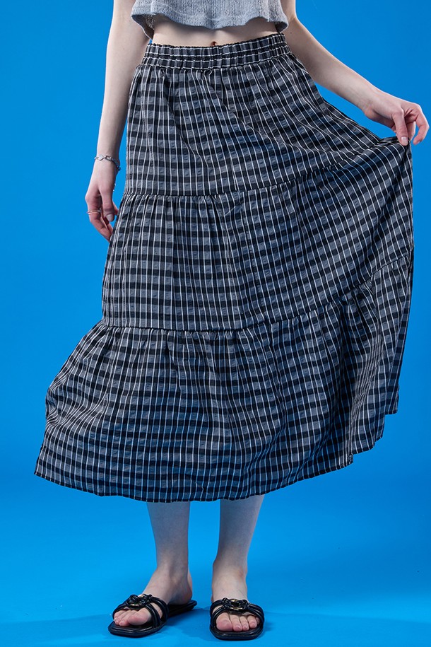 릴리 에어리 쿨링 마몽 체크 롱스커트는 여름철 일상에서 쾌적하게 착용 가능한 블랙 색상의 여성용 스커트입니다. 부드러운 폴리에스테르 소재의 A라인 티어드 디자인으로, 얇은 두께와 통기성, 냉감 및 속건 기능까지 갖춰 시원하게 입을 수 있으며, 밴딩과 안감 처리로 편안함과 비침 방지 기능까지 더했습니다. 루즈핏으로 주름 디자인이 돋보이는 체크 패턴 롱스커트입니다.
