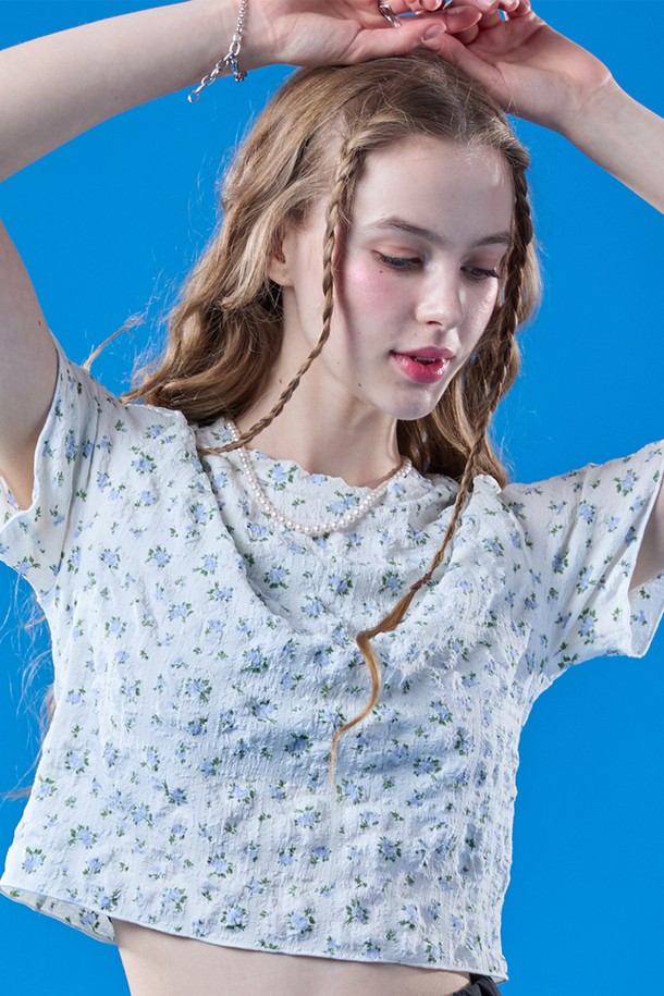 화이트와 블루 컬러의 플라워 패턴이 돋보이는 프릴 멜빈 플라워 크롭 마몽티는 여름철 일상복으로 시원하게 입기 좋은 크롭 기장의 상의입니다. 얇고 통기성이 좋은 소재로 제작되어 쾌적하며, 플리츠 디자인과 슬림핏으로 여성스러운 실루엣을 연출해줍니다. 라운드넥 디자인의 반소매 상의로, 캐주얼한 스타일을 선호하는 여성에게 추천합니다.
