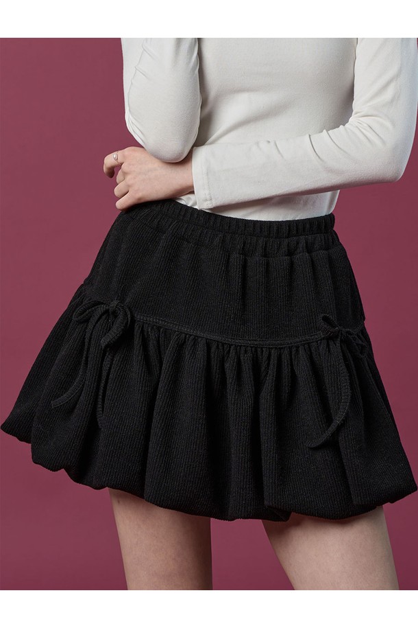 **방한 니트 벌룬 리본 플레어 밴딩 미니스커트 [BLACK] 치마바지 ver.**

따뜻한 겨울과 가을을 위한 여성용 미니스커트입니다. 부드러운 니트 소재로 제작되어 포근한 착용감을 선사하며, 루즈핏 벌룬 디자인과 플레어 스타일로 사랑스러운 분위기를 연출합니다. 허리 밴딩과 리본 디테일이 편안함과 여성스러움을 더하고, 블랙 컬러는 어떤 상의와도 쉽게 매치할 수 있어 활용도가 높습니다. 캐주얼, 미니멀 스타일을 즐겨 입는 분들께 추천하는 아이템입니다.
