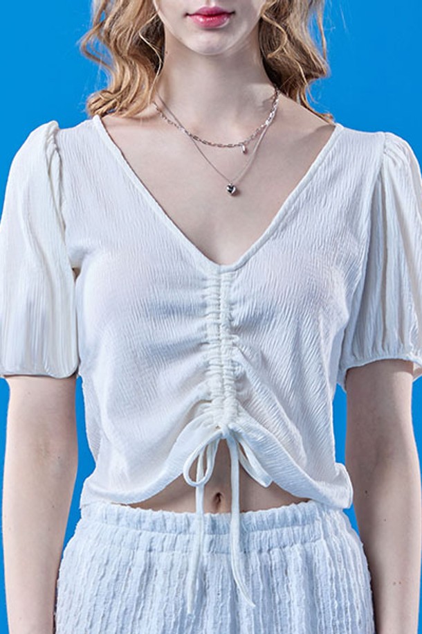 여성스러운 무드를 연출하는 화이트 컬러의 쿨링 플리츠 리본 퍼프 크롭 반팔 티셔츠입니다. 브이넥 디자인에 플리츠, 리본, 퍼프 소매 디테일이 돋보이며, 냉감 기능이 있는 얇은 소재로 여름철에도 시원하게 착용 가능합니다. 크롭 기장으로 스타일리시하게 연출할 수 있습니다.
