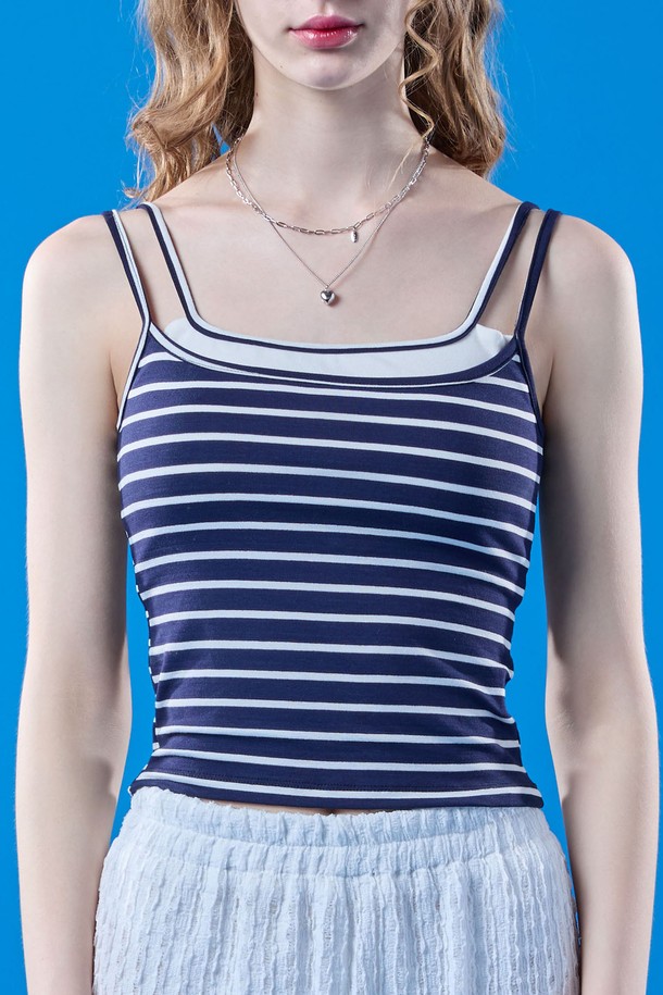 네이비 컬러의 여성용 이너 멀티 나시입니다. 걸리시하고 프레피한 스타일을 연출하며, 여름철 데일리룩에 활용하기 좋습니다. 시원한 민소매 크롭 기장과 스퀘어넥 디자인, 빈티지 스트라이프 패턴이 특징이며, 휴가룩이나 페스티벌 룩으로도 활용할 수 있습니다.
