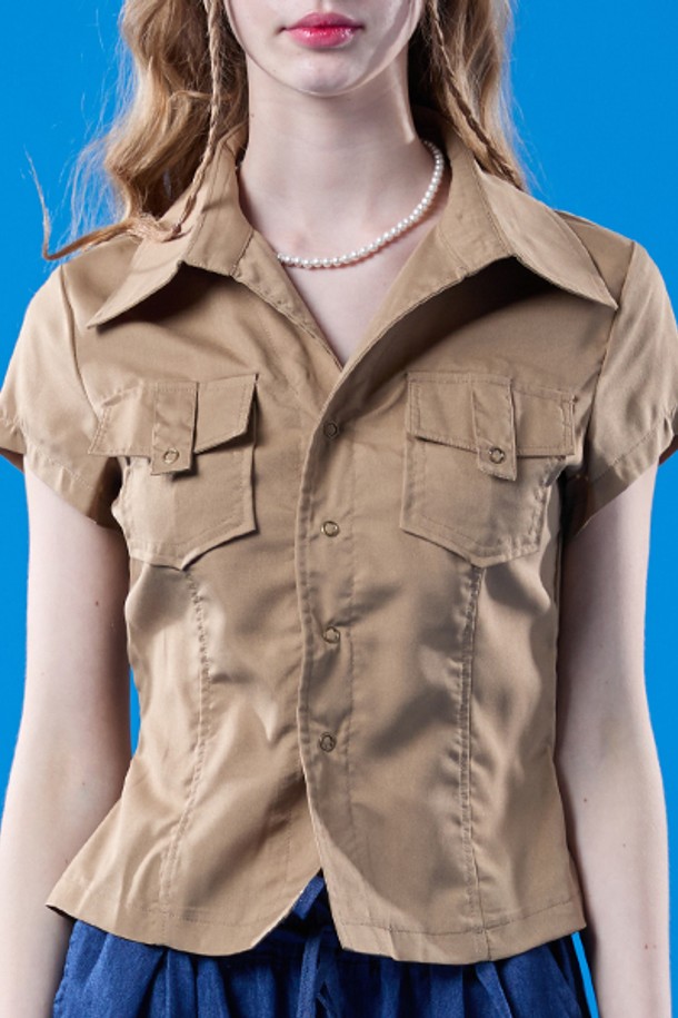 여름 시티 사파리 컬렉션의 베이지색 크롭 슬림핏 반팔 셔츠입니다. 캐주얼한 스타일의 이 셔츠는 얇은 두께감과 반소매 기장으로 시원하게 착용할 수 있으며, 카라 디자인과 사파리 스타일 디테일이 특징입니다. 무지 디자인으로 어떤 하의와도 쉽게 매치하여 일상룩을 연출할 수 있습니다.
