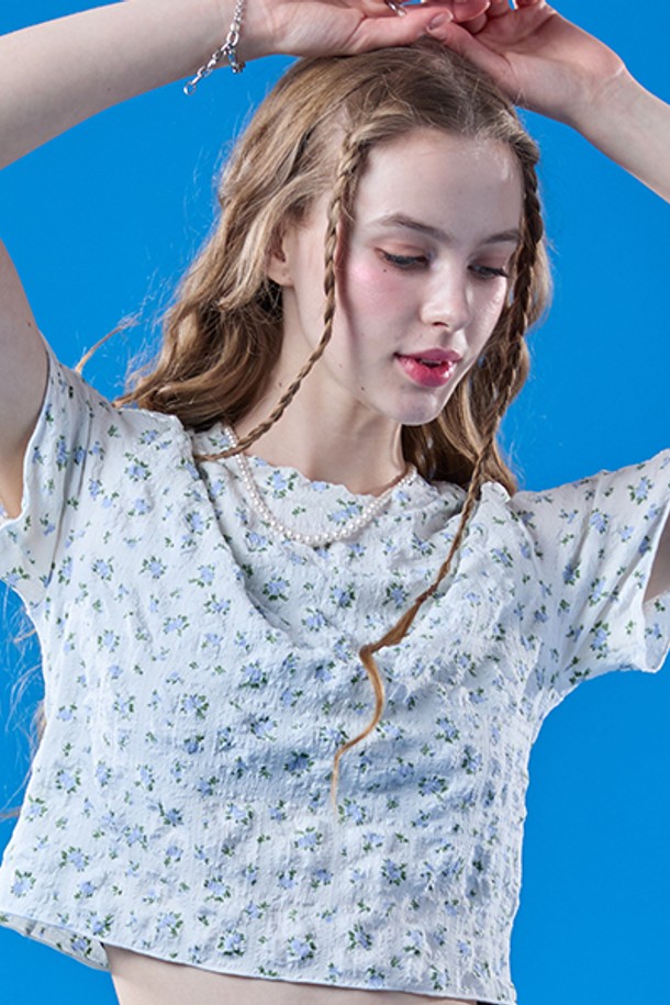 화이트와 블루 컬러의 플라워 패턴이 돋보이는 프릴 멜빈 플라워 크롭 마몽티는 여름철 일상복으로 시원하게 입기 좋은 크롭 기장의 상의입니다. 얇고 통기성이 좋은 소재로 제작되어 쾌적하며, 플리츠 디자인과 슬림핏으로 여성스러운 실루엣을 연출해줍니다. 라운드넥 디자인의 반소매 상의로, 캐주얼한 스타일을 선호하는 여성에게 추천합니다.
