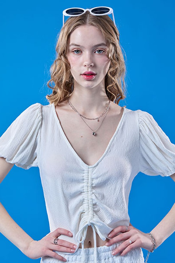 여성스러운 무드를 연출하는 화이트 컬러의 쿨링 플리츠 리본 퍼프 크롭 반팔 티셔츠입니다. 브이넥 디자인에 플리츠, 리본, 퍼프 소매 디테일이 돋보이며, 냉감 기능이 있는 얇은 소재로 여름철에도 시원하게 착용 가능합니다. 크롭 기장으로 스타일리시하게 연출할 수 있습니다.
