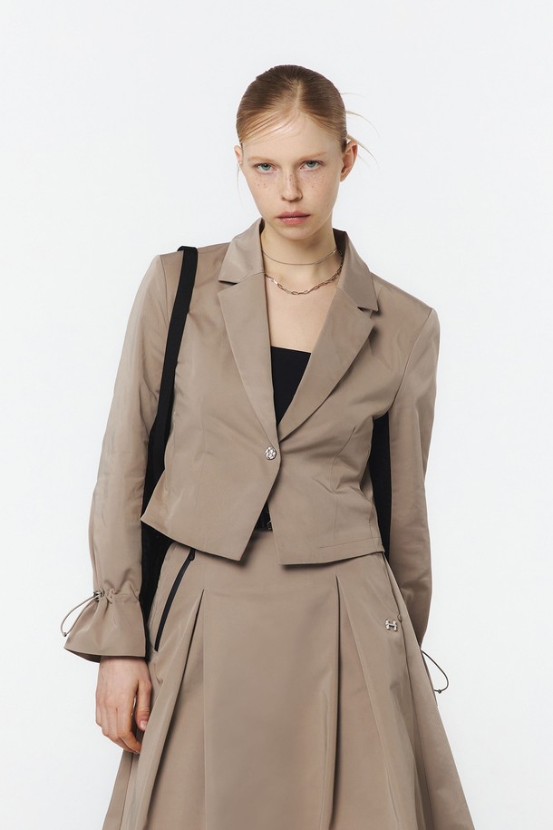 여성용 베이지 색상 테일러드 자켓으로, 봄, 가을에 어울리는 얇은 두께의 폴리에스테르 소재로 제작되었습니다. 크롭 기장의 테일러드 핏으로 클래식하고 미니멀한 무드를 연출하며, 소매 안쪽 다이아몬드 메쉬 구조와 소매 끝단 스트링 스토퍼 디테일이 돋보입니다. 베스트, 스커트와 함께 3피스 세트로도 연출 가능한 활용도 높은 아이템입니다.
