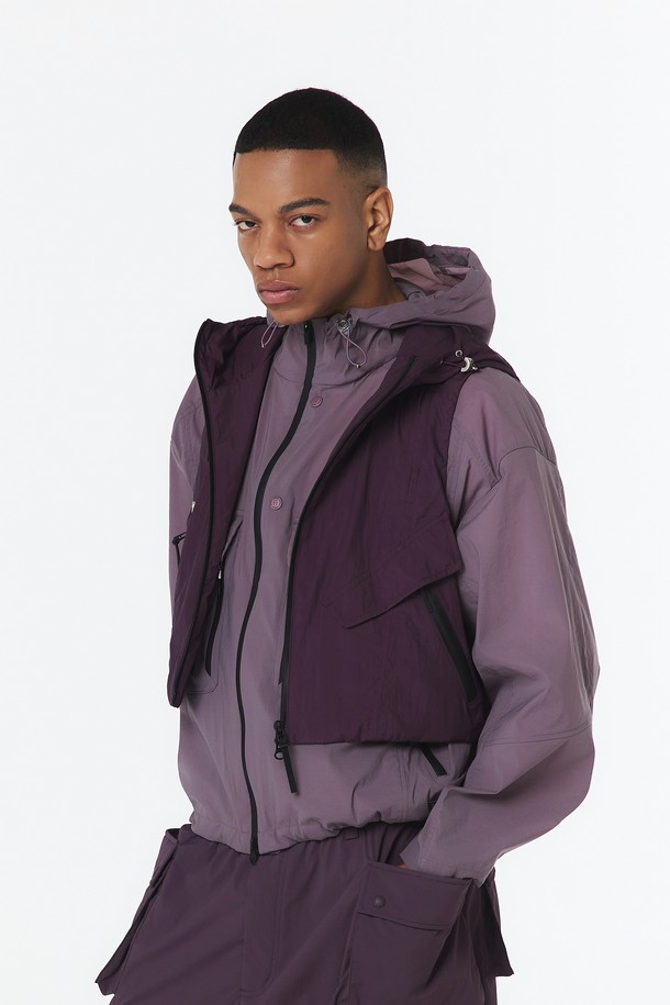 유니 후디베스트는 다크 퍼플 색상의 유니섹스 베스트로, 사계절 활용 가능하며 아웃도어 및 일상에서 스포티하고 캐주얼한 스타일을 연출할 수 있습니다. 나일론과 폴리에스테르 혼방 소재로 제작되었으며, 방수, 방풍, 통기성 기능이 뛰어나 활동성을 높여줍니다. 크롭 기장의 오버핏 디자인에 2-WAY 매트 방수 지퍼와 사이드 매트 방수 지퍼, 후드, 메쉬 안감 등의 디테일이 돋보입니다.
