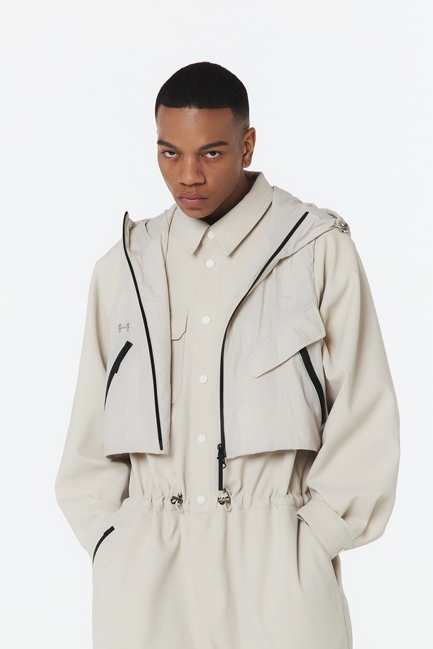 유니 후디베스트 (오트밀)_5LG1411은 사계절 활용 가능한 유니섹스 베스트입니다. 오트밀 색상의 무지 패턴으로, 나일론과 폴리에스테르 혼방 소재를 사용하여 방수, 방풍, 통기성이 뛰어납니다. 2-WAY 매트 방수 지퍼, 사이드 매트 방수 지퍼, 메탈 FF 장식, 앞면 상단 통기성, 후면 자수 로고, 메쉬 안감 등의 디테일과 후드, 오버핏, 크롭 기장이 특징입니다.
