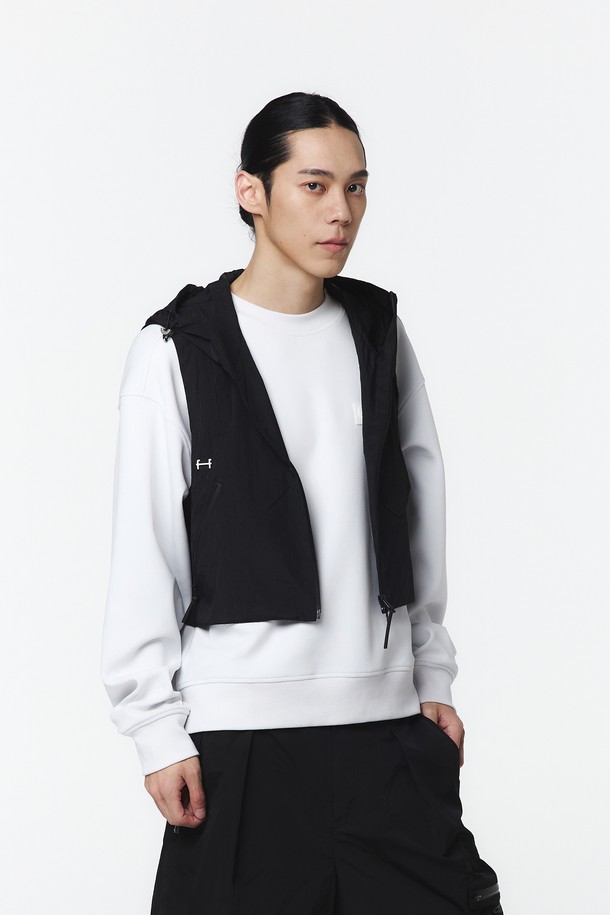 유니 후디베스트 (블랙)_5LG1411은 봄, 가을에 어울리는 유니섹스 아우터 베스트입니다. 블랙 색상의 무지 패턴으로, 크롭 기장의 오버핏 실루엣을 연출하며, 2-WAY 매트 방수 지퍼와 사이드 매트 방수 지퍼, 메탈 장식으로 포인트를 더했습니다. 나일론과 폴리에스테르 혼방 소재에 메쉬 안감, 앞면 상단 통기 기능 및 후면 자수 로고 디테일이 돋보이며, 방수 및 통기성이 우수하여 아웃도어 활동은 물론 일상복으로도 활용하기 좋습니다.
