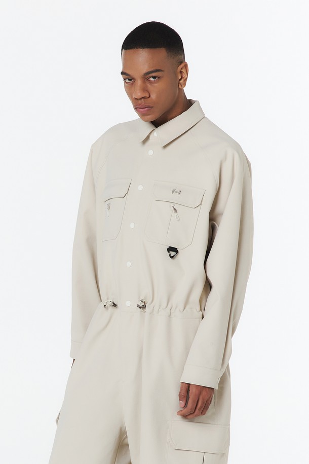 유니 스트링 점프수트 (오트밀)_5LG2911은 부드러운 촉감의 폴리에스테르 트윌 골지 원단으로 제작된 유니섹스 점프수트입니다. 오트밀 컬러의 얇은 두께로 봄, 가을에 적합하며, 방수 및 통기성 기능이 있어 일상복은 물론 가벼운 스포티 스타일에도 잘 어울립니다. 오버핏/루즈핏 디자인에 가슴 지퍼 플래킷, 방수 지퍼 포켓, 허리/밑단 스트링, 등판 통기구, 메탈/자수 로고 디테일까지 더해 캐주얼하면서도 세련된 룩을 연출할 수 있습니다.
