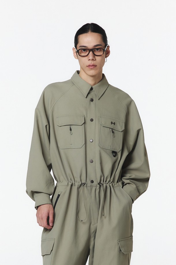 유니 스트링 점프수트 (애쉬 올리브)는 폴리에스테르 소재로 제작되어 가볍고 시원한 착용감을 제공하며, 봄, 여름, 가을 시즌에 적합합니다. 스포티하면서도 캐주얼한 스타일로, 오버핏과 루즈핏의 편안한 핏을 자랑하며, 반소매 기장과 얇은 두께로 활동성을 높였습니다. 앞면 스냅 버튼, 가슴 방수 지퍼 플래킷, 허리 및 밑단 드로스트링, 등판 통기성 디테일과 같은 다양한 기능성 디테일과 메탈 로고 리벳 및 로고 자수 디테일로 디자인의 완성도를 높였습니다.