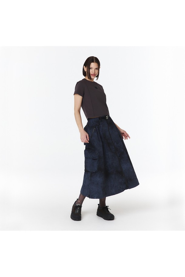 여성용 물나염 셋업 스커트(다크 네이비)_5LB1822는 부드러운 나일론 소재의 A라인 맥시스커트입니다. 스포티하고 캐주얼한 무드를 연출하며, 물나염/타이다이 패턴이 돋보입니다. 방수 기능과 방수 지퍼 포켓, 2-WAY 지퍼, 메탈 버클 디테일이 있으며, 점퍼 5LG1322와 셋업하여 착용 가능합니다.
