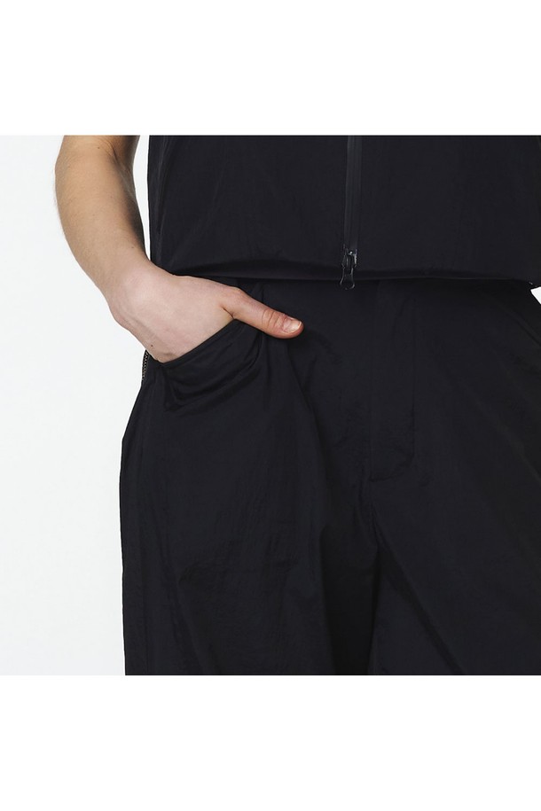 세로 절개 라인이 돋보이는 블랙 색상의 여성 긴팔 스탠드 칼라 셋업 바지입니다. 나일론 소재로 제작되었으며, 와이드핏과 뒷허리 밴딩으로 편안한 착용감을 제공하고, 앞포켓 이중 구성과 뒤 박스 아웃포켓 디테일을 더했습니다. 5LB1312 점퍼와 셋업으로 연출 가능하며, 봄, 가을 일상복으로 미니멀하고 스포티한 스타일을 완성할 수 있습니다.
