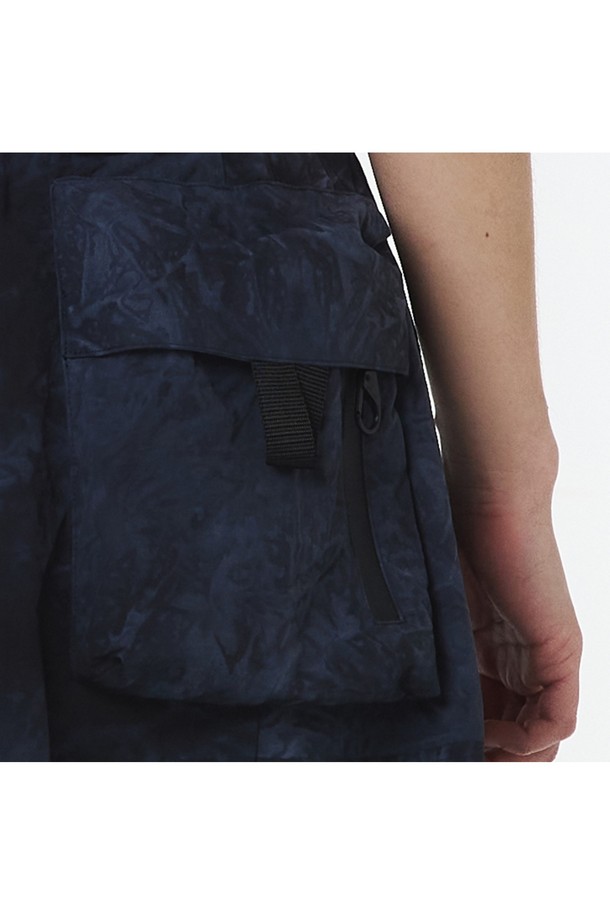 여성용 물나염 셋업 스커트(다크 네이비)_5LB1822는 부드러운 나일론 소재의 A라인 맥시스커트입니다. 스포티하고 캐주얼한 무드를 연출하며, 물나염/타이다이 패턴이 돋보입니다. 방수 기능과 방수 지퍼 포켓, 2-WAY 지퍼, 메탈 버클 디테일이 있으며, 점퍼 5LG1322와 셋업하여 착용 가능합니다.
