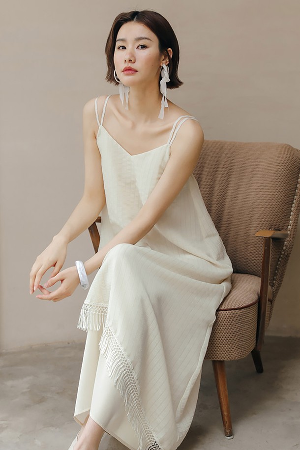 LS 페어리 태슬 민소매 원피스는 우아하고 엘레강스한 스타일을 연출하는 여성 의류입니다. 아이보리 컬러의 얇고 부드러운 폴리에스테르 소재로 제작되어 봄, 여름에 시원하게 착용하기 좋습니다. A라인 플레어 스커트와 루즈핏으로 편안함을 더하며, V넥 민소매 디자인에 태슬 장식과 비대칭 밑단으로 포인트를 주었습니다. 데이트룩, 카페룩, 여행룩 등 다양한 TPO에 맞춰 클래식, 미니멀, 로맨틱한 스타일을 완성해보세요.