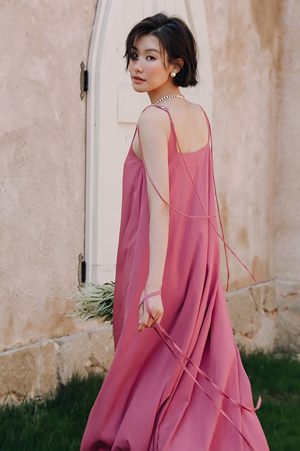 LS 숄더 버튼 민소매 원피스는 우아하고 엘레강스한 무드를 연출하는 여성용 슬리브리스 원피스입니다. 핑크 컬러의 폴리에스테르 소재로 제작되어 봄, 여름에 시원하게 착용하기 좋습니다. A라인 플레어 치마 타입에 루즈핏으로 편안하면서도 여성스러운 실루엣을 선사합니다. V넥 디자인과 어깨 스트랩, 버튼 디테일이 더해져 데이트룩, 카페룩, 여행룩 등 다양한 TPO에 클래식, 로맨틱, 미니멀 스타일을 연출할 수 있습니다.
