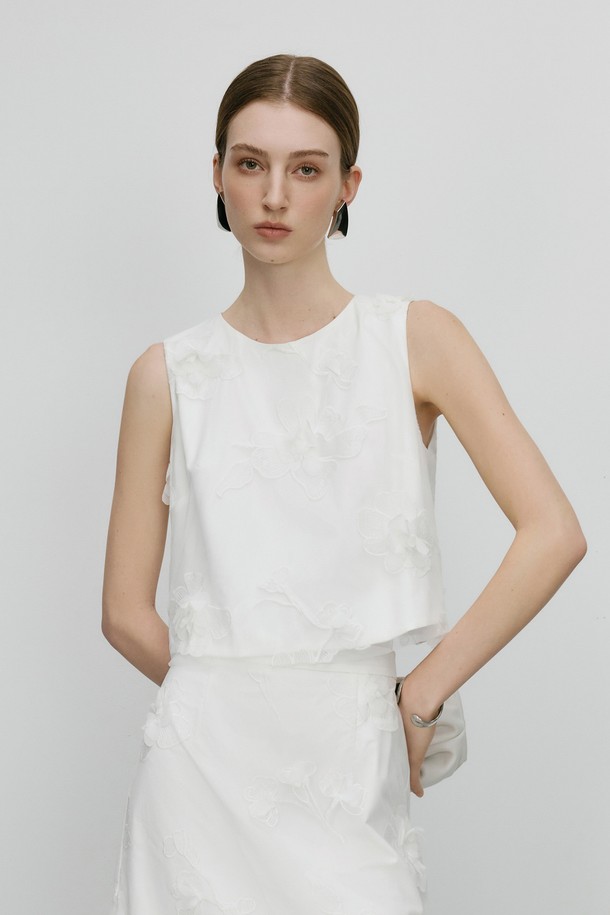 WD_Flower 민소매 탑은 부드러운 폴리에스테르 소재로 제작되어 편안한 착용감을 선사합니다. 화이트 컬러의 무지 디자인에 뒷면 리본 디테일과 레이어드 디자인이 더해져 미니멀하면서도 세련된 스타일을 연출하며, 얇은 두께감으로 봄 시즌에 적합합니다. 라운드넥 레귤러핏으로 어떤 하의와도 잘 어울리며, 구조적인 실루엣이 돋보입니다.
