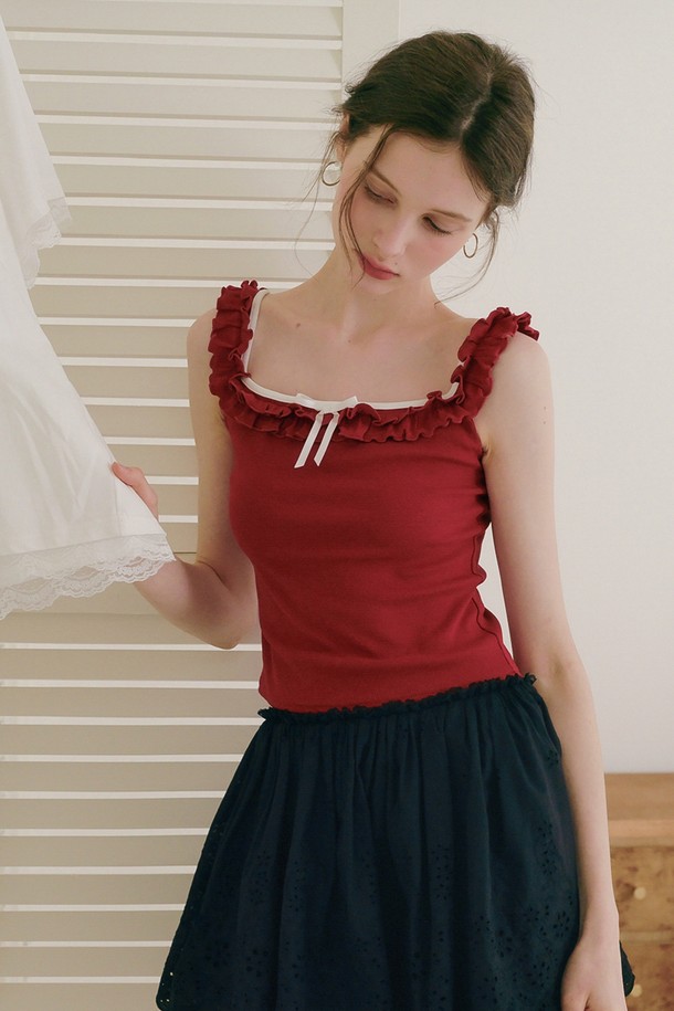 **Ruffle sleeveless top ( 러플 슬리브리스 탑 )**

산뜻한 레드 컬러의 러플 디테일이 돋보이는 여성용 민소매 탑입니다. 면, 비스코스, 폴리에스테르 혼방 소재로 제작되어 부드러운 촉감과 편안한 착용감을 선사합니다. 스퀘어넥 라인과 레귤러핏으로 우아한 실루엣을 연출하며, 리본 장식으로 사랑스러운 포인트를 더했습니다. 데이트룩, 카페룩, 모임룩 등 다양한 TPO에 활용 가능하며, 클래식, 로맨틱, 미니멀 스타일을 즐기는 분들께 추천합니다. 코디를 위한 스커트는 별도 판매합니다.
