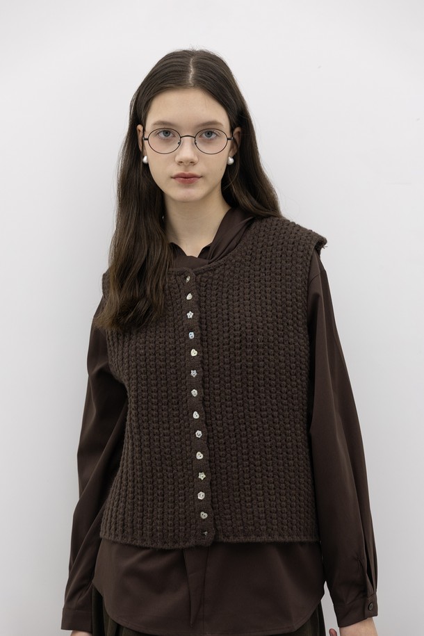 **그리드 니트 베스트_브라운**

부드러운 울 소재의 여성용 니트 베스트입니다. 가을, 겨울 시즌에 어울리는 두꺼운 두께감으로 따뜻하게 착용할 수 있습니다. 라운드넥과 레귤러핏 디자인에 클래식하고 베이직한 무드를 더했습니다. 그리드 패턴의 케이블 니트 짜임과 단추 디테일, 버튼업 스타일이 특징이며, 모임룩, 미니멀, 캐주얼 스타일 모두 소화 가능합니다. 민소매 기장으로 다양한 상의와 레이어드하여 연출하기 좋습니다.
