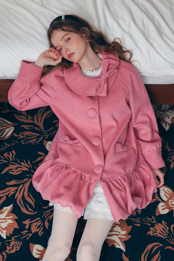 **Bow collar balloon coat (보우 칼라 발룬 코트)**는 우아하고 로맨틱한 분위기를 연출하는 여성 코트입니다. 부드러운 울 소재로 제작되어 포근하며, 두꺼운 두께감으로 가을, 겨울철에 따뜻하게 착용할 수 있습니다. 핑크 컬러의 무지 디자인에 리본 칼라와 프릴 디테일이 더해져 여성스러운 매력을 더합니다. 루즈핏 발룬 스타일로 편안하면서도 엘레강스한 핏을 선사하며, 데이트룩이나 모임룩에 완벽하게 어울립니다. 싱글 버튼 여밈과 긴 소매 기장으로 클래식하면서도 미니멀한 스타일을 완성합니다.
