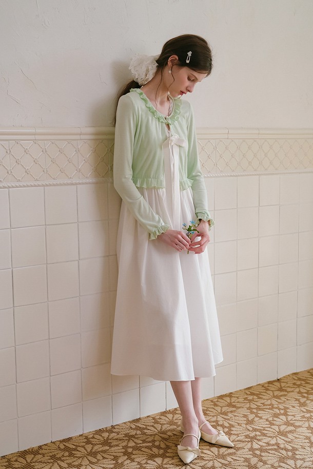 산뜻한 민트 컬러의 프릴 크롭 가디건입니다. 면, 모달, 스판덱스 혼방 소재로 제작되어 부드러운 촉감과 편안한 착용감을 선사하며, 봄, 여름 시즌에 활용하기 좋습니다. 라운드넥에 긴 소매, 레귤러핏으로 디자인되었으며, 프릴 디테일과 리본 장식이 우아한 스타일을 더합니다.
