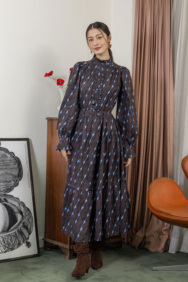 티크 블룸 쉬어 드레스_브라운은 여성스러운 매력을 돋보이게 하는 원피스입니다. 부드러운 면 소재로 제작되어 편안한 착용감을 선사하며, 봄, 여름에 어울리는 얇은 두께감과 루즈핏으로 시원하게 즐길 수 있습니다. A라인 플레어 스커트, 체크 패턴과 긴 소매, 라운드넥 디자인이 우아하고 클래식한 분위기를 연출합니다. 리본 디테일과 허리 조절 가능한 디자인, 비대칭 디자인으로 포인트를 더했으며, 데이트룩, 카페룩, 모임룩 등 다양한 TPO에 활용 가능합니다.
