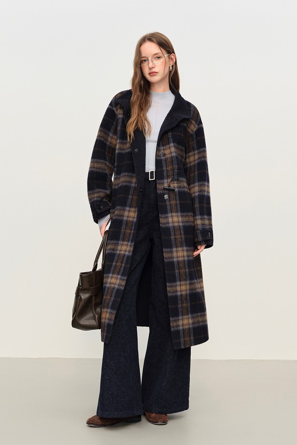 네이비와 브라운 컬러의 플레드 체크 패턴이 돋보이는 혼 버튼 벨티드 코트입니다. 울 소재로 제작되어 부드러운 촉감과 뛰어난 보온성을 제공하며, 롱 기장의 오버핏 디자인으로 편안하면서도 클래식한 분위기를 연출합니다. 허리 벨트가 포함되어 있어, 스타일리시한 실루엣을 강조할 수 있으며, 가을, 겨울 시즌 출근룩, 모임룩, 데이트룩 등 다양한 TPO에 활용 가능합니다. 캐주얼, 클래식, 미니멀한 스타일을 즐기는 여성분들께 추천합니다. 두꺼운 두께감으로 추운 날씨에도 따뜻하게 착용할 수 있습니다.
