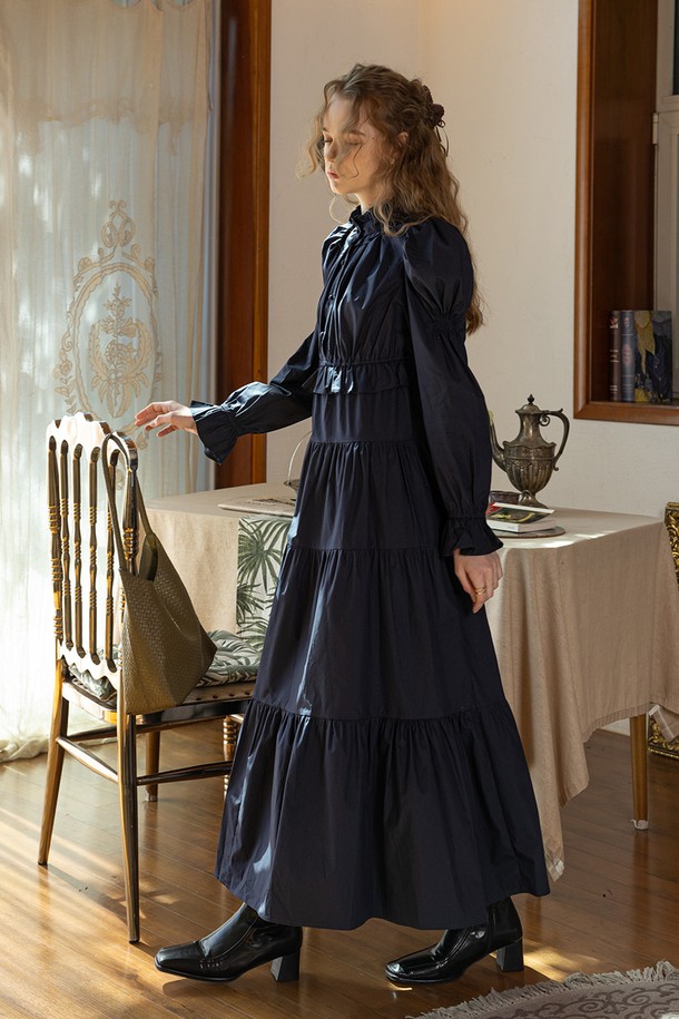 Palace 러플 코튼 드레스_네이비는 여성스러운 실루엣을 강조하는 우아하고 페미닌한 무드의 미디 기장 원피스입니다. 부드러운 면 소재로 제작되어 편안한 착용감을 선사하며, 봄, 여름 시즌에 적합합니다. 라운드넥과 긴소매 디자인에 러플과 티어드 디테일을 더해 로맨틱한 분위기를 연출합니다. A라인 플레어 치마핏과 루즈핏으로 활동성을 높였으며, 데이트룩과 모임룩에 잘 어울립니다. 클래식, 로맨틱, 미니멀 스타일을 즐겨 입는 분들께 추천합니다.
