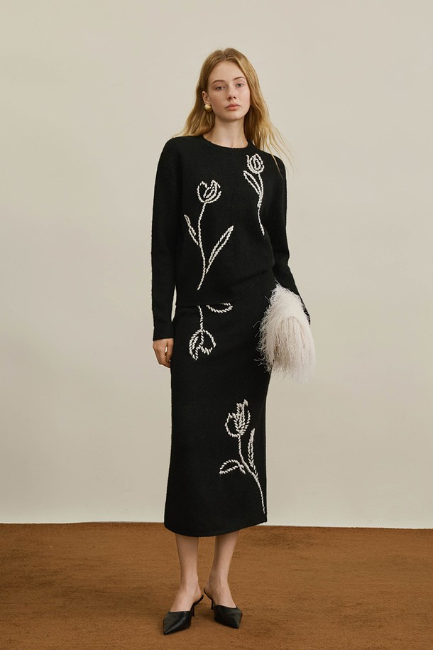 세련된 블랙 컬러의 튤립 플라워 디자인 스커트입니다. 미디 기장(미디스커트)의 H라인으로 떨어져 슬림핏을 연출하며, 봄, 가을에 어울리는 아이템입니다. 튤립 자수 디테일이 돋보이며, 미니멀하고 엘레강스한 스타일을 선호하는 여성분들께 추천합니다. 데이트룩, 모임룩, 오피스룩 등 다양한 TPO에 활용할 수 있으며, 클래식하고 로맨틱한 무드를 더해줍니다.
