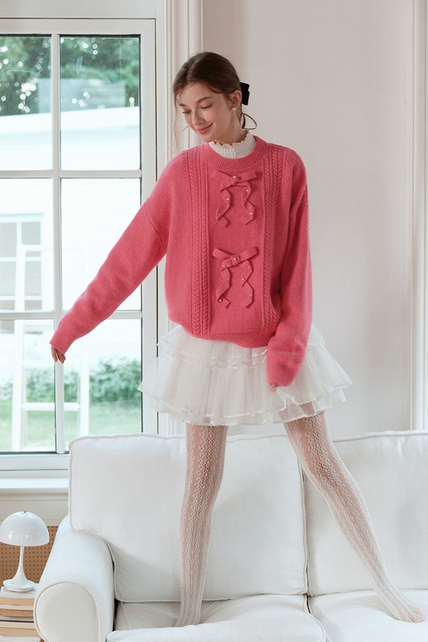 진주 리본 니트 풀오버 스웨터는 가을과 겨울에 따뜻함과 우아함을 선사하는 여성용 니트/스웨터입니다. 핑크 컬러에 케이블 패턴, 레귤러 핏, 라운드넥 디자인으로 부드러운 촉감을 자랑하며, 두꺼운 두께로 보온성을 높였습니다. 

긴 소매와 프릴 디테일, 리본 장식, 진주 장식으로 로맨틱하고 우아한 분위기를 연출하여 데이트룩, 모임룩에 적합합니다. 캐주얼, 클래식, 로맨틱 스타일을 모두 소화할 수 있는 활용도 높은 아이템입니다.
