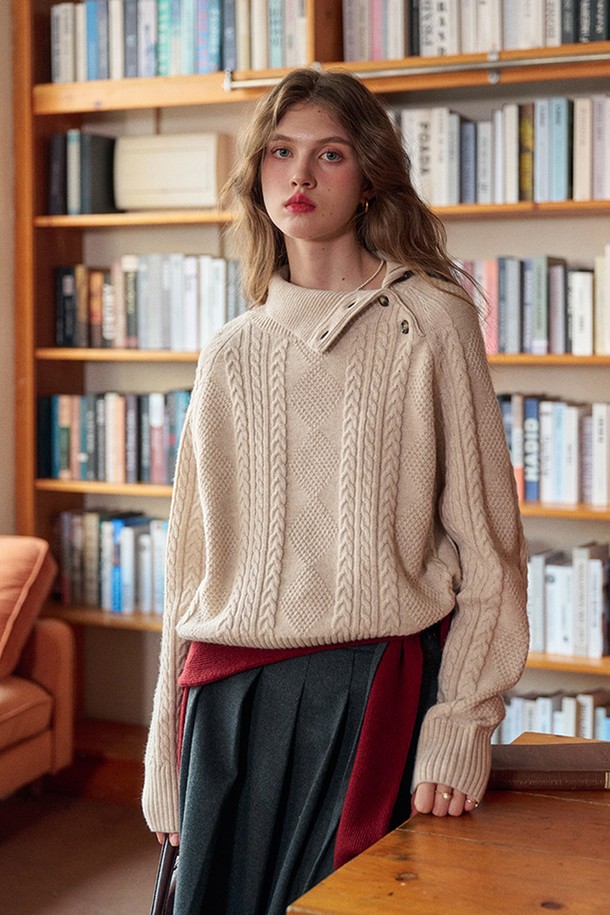 플래킷 터틀넥 케이블 니트는 여성용 상의로, 가을과 겨울에 따뜻하게 착용하기 좋은 두꺼운 두께감의 니트/스웨터입니다. 아이보리와 베이지 두 가지 색상으로 출시되었으며, 베이직하고 클래식한 스타일을 연출합니다. 루즈핏의 크롭 기장으로, 출근룩과 모임룩 모두에 활용 가능하며, 플래킷 디테일이 돋보입니다. 울과 아크릴 혼방 소재의 부드러운 촉감과 케이블 패턴이 특징이며, 민소매 디자인의 터틀넥 스타일로 클래식, 미니멀, 캐주얼 룩에 모두 잘 어울립니다.
