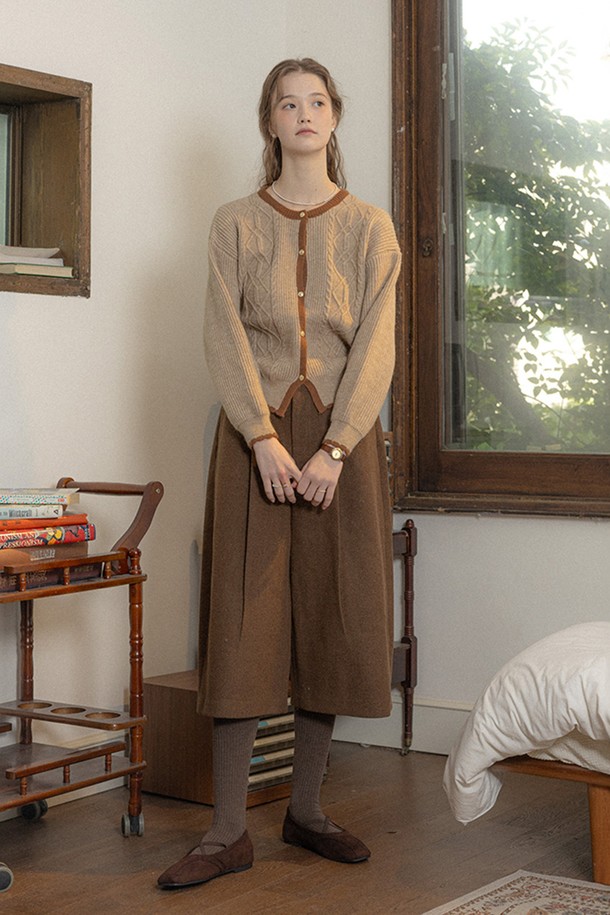 우아한 브라운 컬러의 니트 가디건입니다. 울과 아크릴 혼방 소재로 제작되어 부드러운 촉감과 뛰어난 보온성을 제공하며, 두꺼운 두께감으로 가을, 겨울철 따뜻하게 착용하기 좋습니다. 클래식하고 엘레강스한 무드를 연출하며, 라운드넥과 레귤러핏으로 다양한 스타일과 잘 어울립니다. 케이블 패턴과 버튼 디테일이 돋보이며, 오피스룩 또는 모임룩에 세련되게 매치할 수 있습니다.
