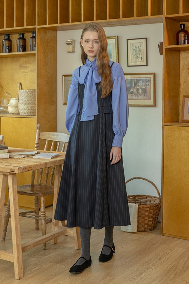 블랙 컬러의 클래식 스트라이프 캐미솔 원피스입니다. A라인 플리츠 스커트와 스퀘어 넥 디자인으로, 여성스러운 실루엣을 연출합니다. 민소매 디자인으로 봄, 여름에 시원하게 착용 가능하며, 데이트룩 또는 모임룩으로 활용하기 좋습니다. 미니멀하면서도 엘레강스한 스타일을 선호하는 분들께 추천합니다. 캐미솔 스타일의 미디 기장으로, 클래식하면서도 세련된 분위기를 더합니다.
