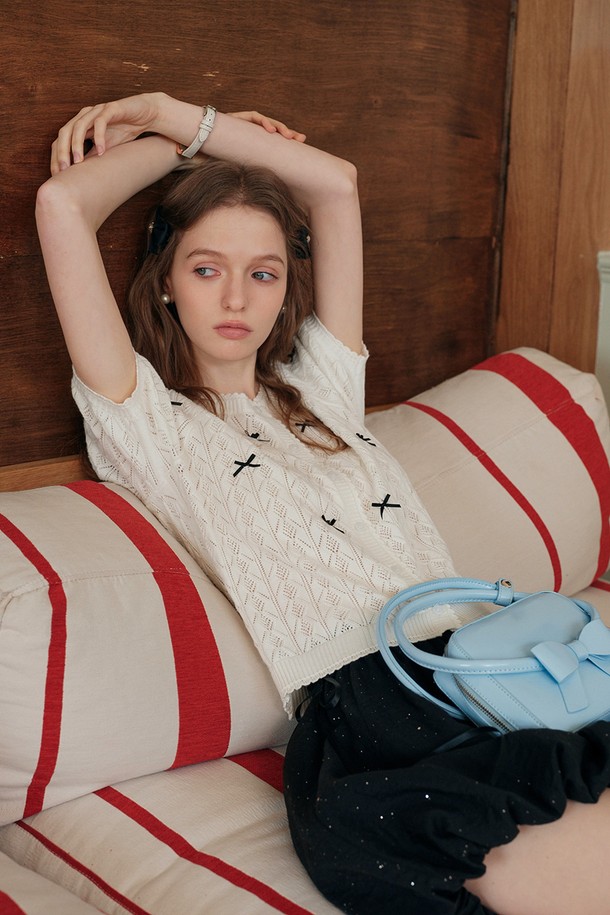 부드러운 촉감의 화이트 컬러 크로셰 리본 반팔 크롭 가디건입니다. 폴리에스테르, 울, 나일론 혼방 소재로 봄, 여름 시즌에 적합하며, 케이블 패턴의 니트 짜임 디테일이 돋보입니다. 라운드 넥과 레귤러 핏, 리본 장식으로 우아하고 캐주얼한 스타일을 연출하며, 리본은 고정되어 있어 편안하게 착용할 수 있습니다.
