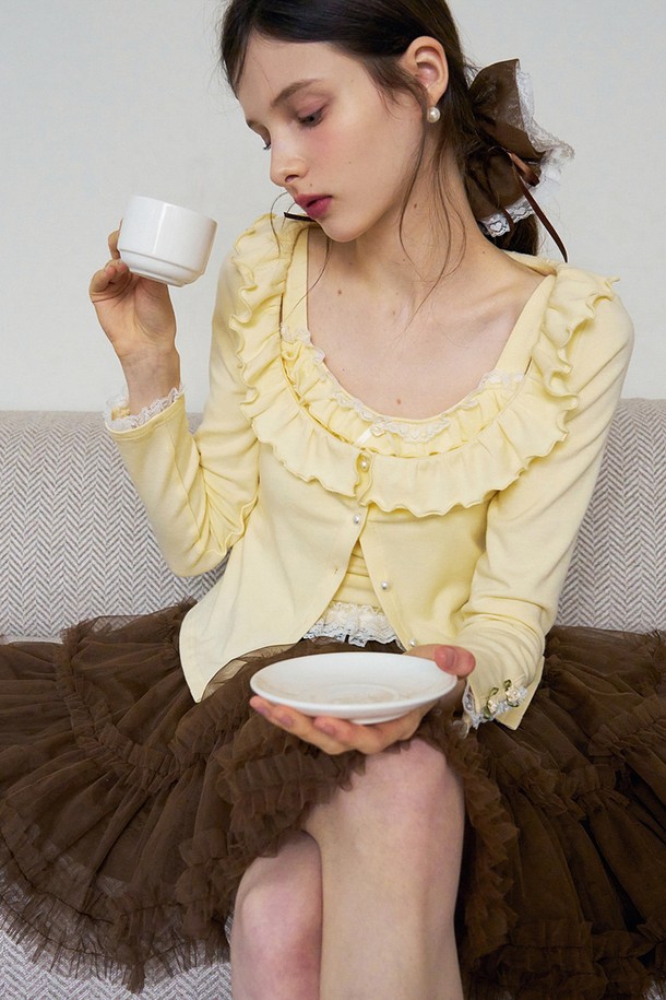 **Ruffle pearl button cardigan (러플 펄 버튼 가디건)**

부드러운 촉감의 옐로우 컬러 여성용 가디건입니다. 면, 비스코스, 폴리에스터 혼방 소재로 제작되어 여름과 가을에 얇고 시원하게 착용할 수 있습니다. 라운드넥에 레귤러 핏으로, 러플 디테일과 진주 버튼, 레이스 장식이 더해져 우아하고 클래식한 분위기를 연출합니다. 긴 소매 기장과 무지 패턴으로 데이트룩, 카페룩, 모임룩 등 다양한 TPO에 활용할 수 있습니다. 미니멀, 로맨틱, 클래식 스타일을 즐겨 입는 여성분들께 추천합니다.
