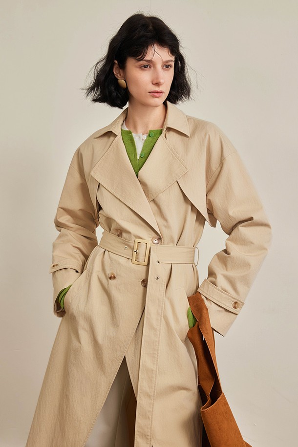 랩펠 허리 밴드 트렌치 코트_2컬러는 여성용 아우터 트렌치 코트입니다. 베이지와 네이비 두 가지 색상으로 출시되었으며, 가을과 겨울에 착용하기 좋습니다. 롱 기장의 레귤러핏으로 클래식하고 베이직한 스타일을 연출하며, 허리 스트랩과 안감이 있어 실용성을 더했습니다. 면, 나일론, 텐셀 혼방 소재로 제작되어 적당한 두께감과 편안한 착용감을 제공합니다. 출근룩, 오피스룩, 가을 나들이룩에 잘 어울리는 미니멀하고 시크한 디자인의 트렌치 코트입니다.
