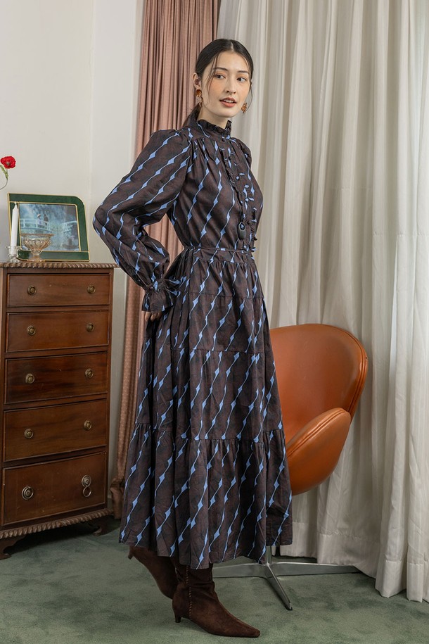 티크 블룸 쉬어 드레스_브라운은 여성스러운 매력을 돋보이게 하는 원피스입니다. 부드러운 면 소재로 제작되어 편안한 착용감을 선사하며, 봄, 여름에 어울리는 얇은 두께감과 루즈핏으로 시원하게 즐길 수 있습니다. A라인 플레어 스커트, 체크 패턴과 긴 소매, 라운드넥 디자인이 우아하고 클래식한 분위기를 연출합니다. 리본 디테일과 허리 조절 가능한 디자인, 비대칭 디자인으로 포인트를 더했으며, 데이트룩, 카페룩, 모임룩 등 다양한 TPO에 활용 가능합니다.
