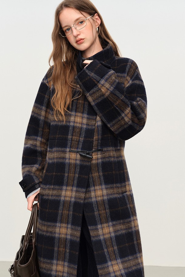 네이비와 브라운 컬러의 플레드 체크 패턴이 돋보이는 혼 버튼 벨티드 코트입니다. 울 소재로 제작되어 부드러운 촉감과 뛰어난 보온성을 제공하며, 롱 기장의 오버핏 디자인으로 편안하면서도 클래식한 분위기를 연출합니다. 허리 벨트가 포함되어 있어, 스타일리시한 실루엣을 강조할 수 있으며, 가을, 겨울 시즌 출근룩, 모임룩, 데이트룩 등 다양한 TPO에 활용 가능합니다. 캐주얼, 클래식, 미니멀한 스타일을 즐기는 여성분들께 추천합니다. 두꺼운 두께감으로 추운 날씨에도 따뜻하게 착용할 수 있습니다.
