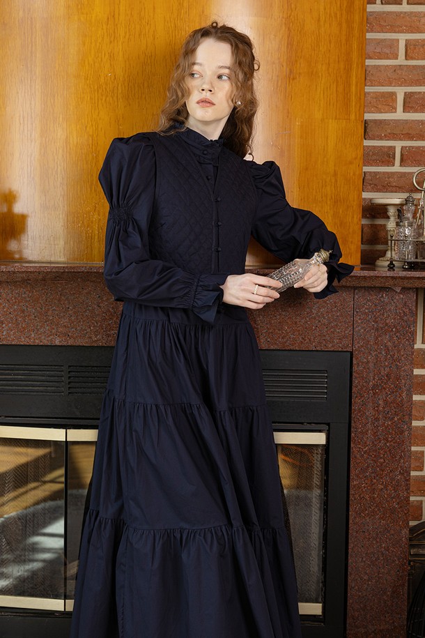 Palace 러플 코튼 드레스_네이비는 여성스러운 실루엣을 강조하는 우아하고 페미닌한 무드의 미디 기장 원피스입니다. 부드러운 면 소재로 제작되어 편안한 착용감을 선사하며, 봄, 여름 시즌에 적합합니다. 라운드넥과 긴소매 디자인에 러플과 티어드 디테일을 더해 로맨틱한 분위기를 연출합니다. A라인 플레어 치마핏과 루즈핏으로 활동성을 높였으며, 데이트룩과 모임룩에 잘 어울립니다. 클래식, 로맨틱, 미니멀 스타일을 즐겨 입는 분들께 추천합니다.
