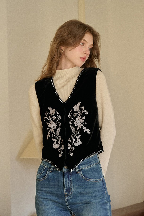 블랙 색상의 자수 벨벳 베스트입니다. 부드러운 벨벳 소재로 제작되어 가을, 겨울 시즌에 따뜻하게 착용할 수 있습니다. 민소매 디자인과 브이넥 라인이 클래식하면서도 엘레강스한 무드를 연출합니다. 플라워 자수 디테일이 돋보이며, 레귤러핏으로 편안하게 착용 가능합니다. 모임룩, 연말 모임룩에 미니멀하면서도 세련된 스타일을 더해보세요.
