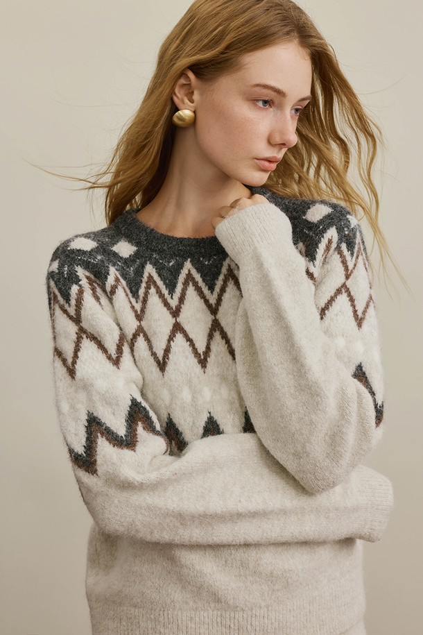 아이보리와 그레이 컬러 배색의 페어아일 무늬가 돋보이는 캐주얼 니트 탑입니다. 부드러운 울 소재로 제작되어 가을, 겨울 시즌에 따뜻하고 포근하게 착용할 수 있습니다. 레귤러 핏과 라운드넥 디자인으로 편안한 착용감을 선사하며, 긴 소매 기장으로 보온성을 높였습니다. 두꺼운 두께감으로 추운 날씨에도 든든하게 몸을 감싸주어 일상에서 활용하기 좋은 아이템입니다. 노르딕 패턴이 더해져 캐주얼하면서도 클래식한 스타일을 연출합니다.
